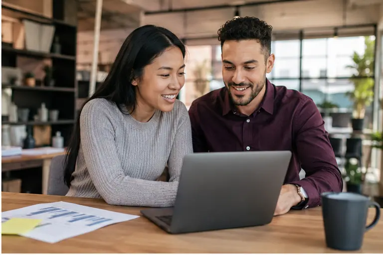 Two business owners reviewing marketing performance on a laptop